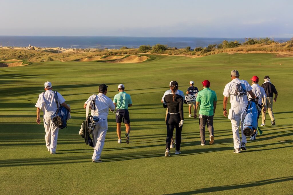 Players and caddies make their way across El Cardonal at Diamante — a course defined by its meticulous design, dramatic bluffs, and Pacific panoramas. Image credit; Ocean Blue Productions