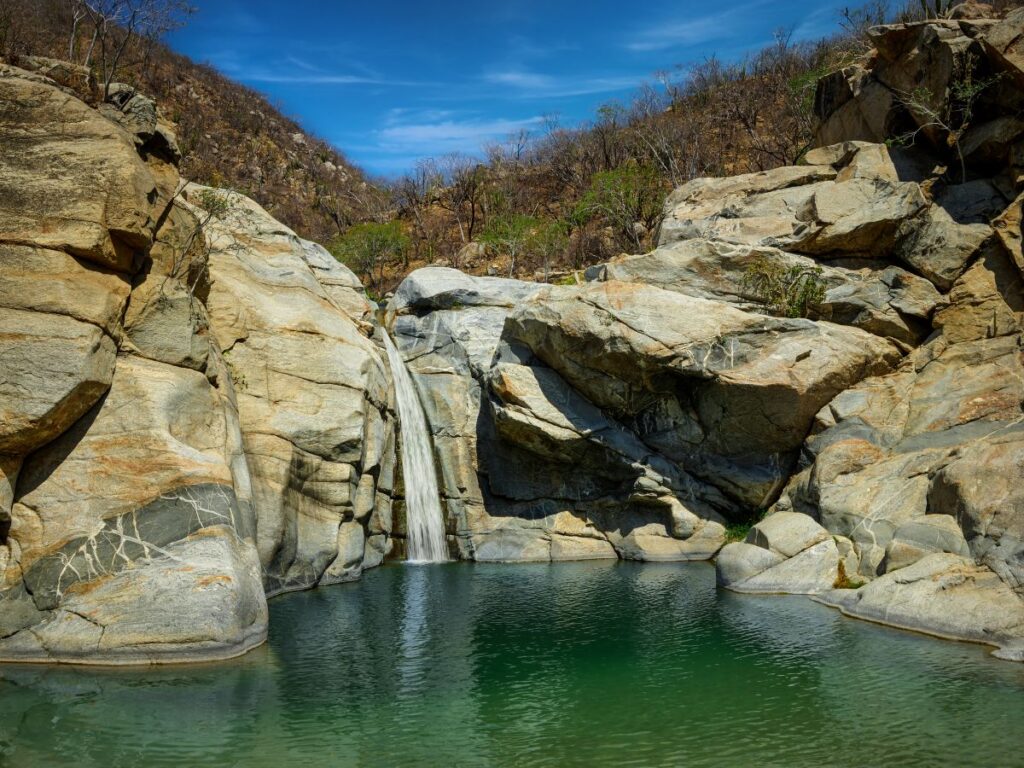 Sol de Mayo waterfall—where desert canyons give way to cascading water and a serene natural pool, offering a refreshing pause in the heart of Santiago. Image credit: Los Cabos Tourism Board